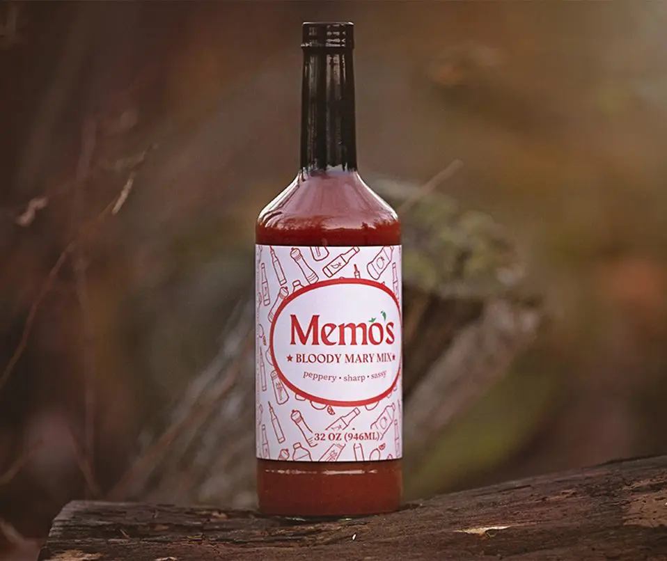 A bottle of sauce sitting on top of a wooden table.