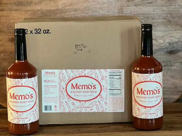 A box of memos hot sauce with two bottles.